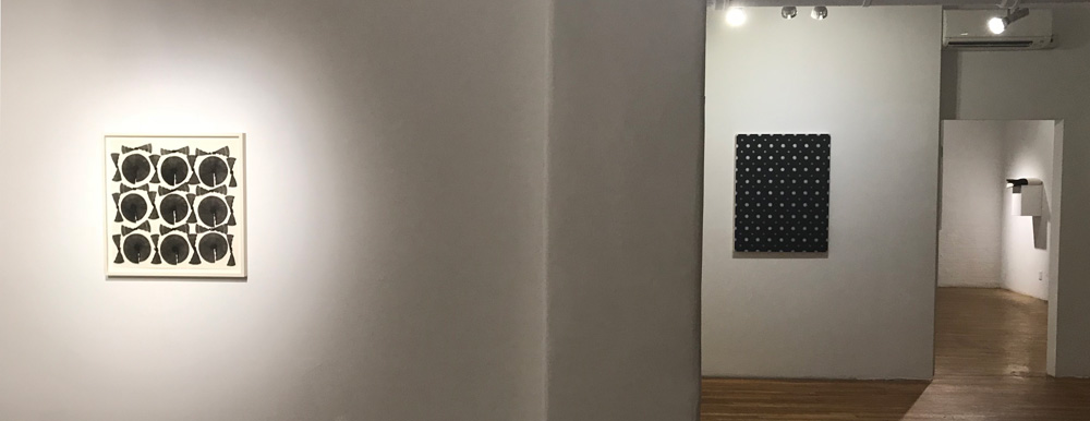 Westbeth Gallery view of a framed ink on paper, a painting on the wall beyond, and work seen through a doorway.